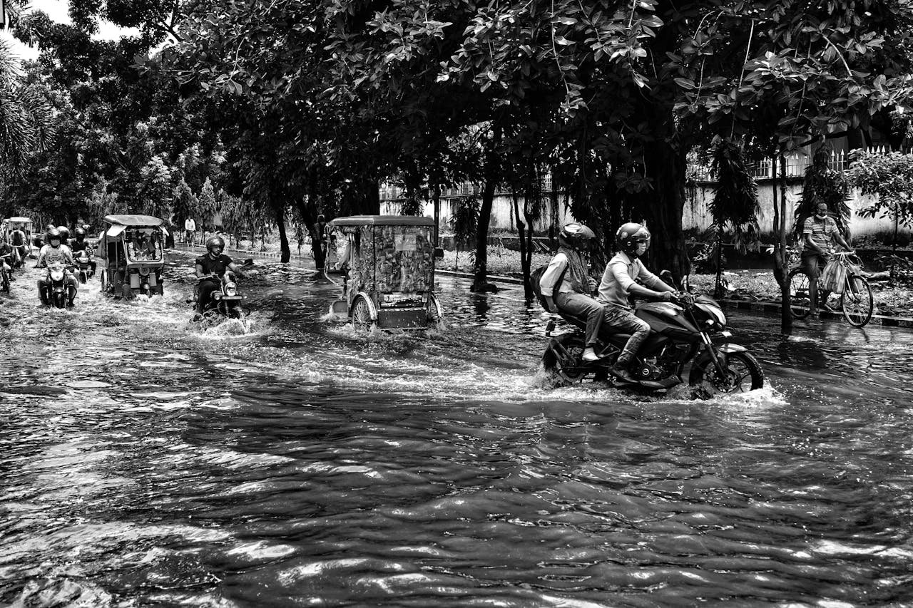 People Riding Motorbikes and Rickshaws on Street during Flood