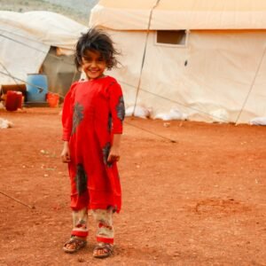 A young child standing in front of a tent