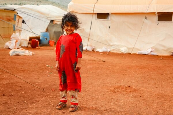 A young child standing in front of a tent