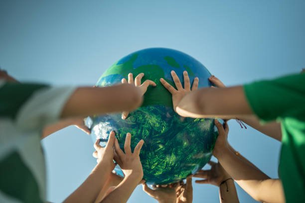 Children holding a planet outdoors